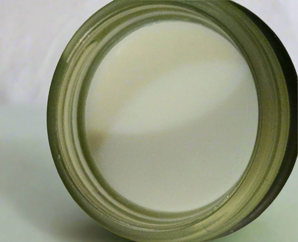 Close-up of a jar with a white substance inside on a light wooden surface