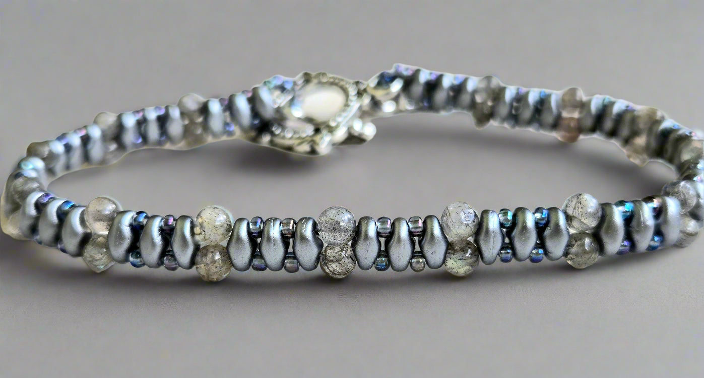 Silver bracelet with small beads on a light wooden surface