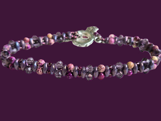 Purple beaded bracelet on a light wooden surface