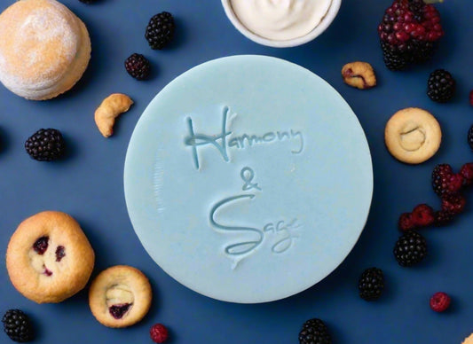Round light blue bar of soap with 'Harmony & Sage' branding on a wooden surface