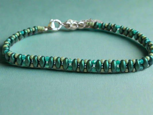 Green beaded bracelet on a light wooden surface