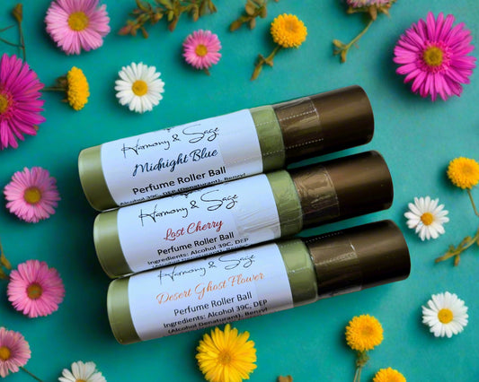 Three perfume roller balls with labels on a wooden surface