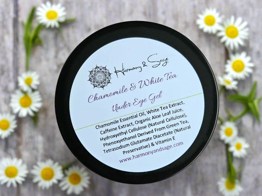 Container of Chamomile & White Tea Under Eye Gel with label on a wooden surface