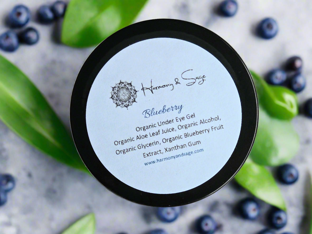 Container of Harmony & Sage Blueberry Organic Under Eye Gel on a wooden surface