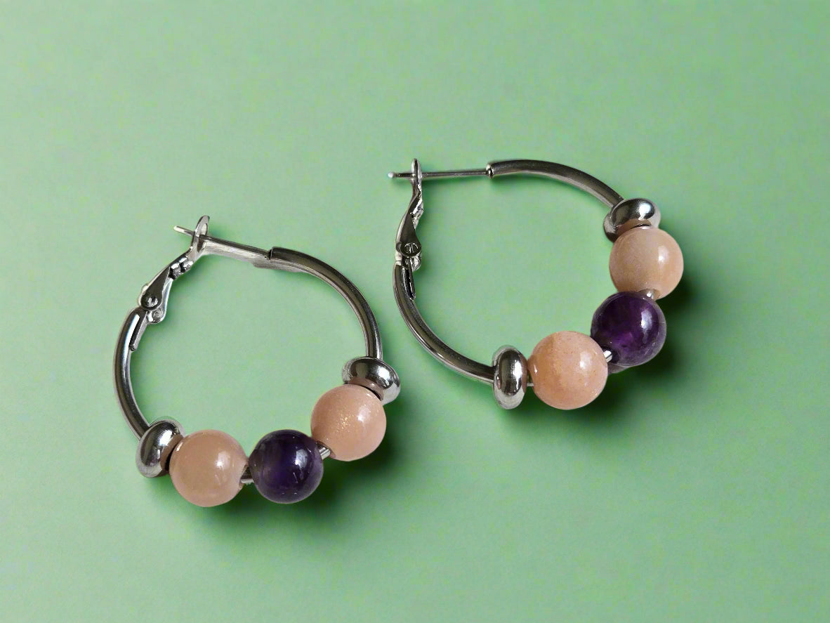 Pair of hoop earrings with beaded accents on a wooden surface