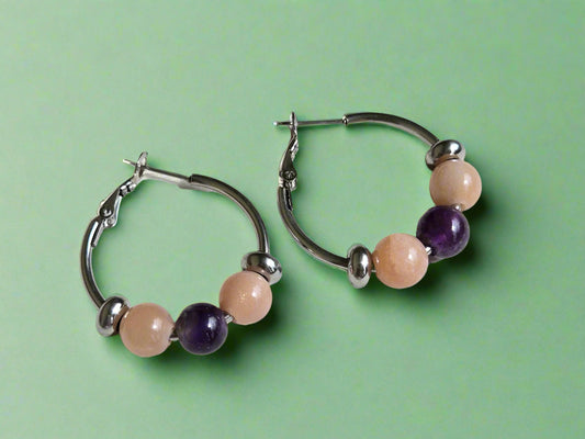 Pair of hoop earrings with beaded accents on a wooden surface