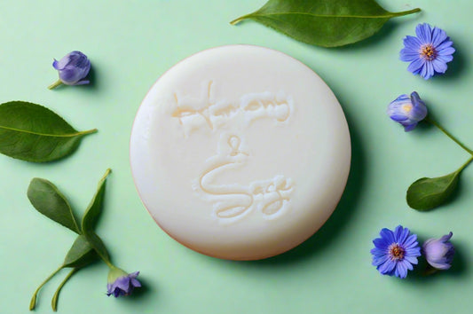 White bar of soap with embossed text on a wooden surface